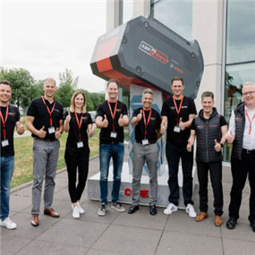 A group of seven people shows thumbs up in front of a Bosch tool.