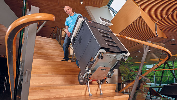 Mann trägt einen schwarzen Bosch Werkzeugkoffer die Treppe hinunter.