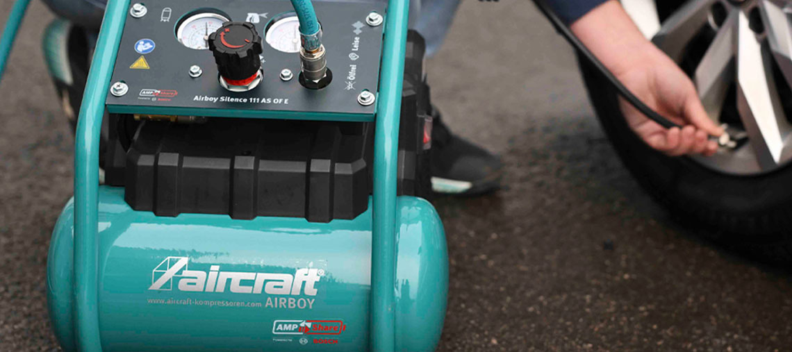 Ein grüner Aircraft Airboy Kompressor wird zum Reifenfüllen genutzt.