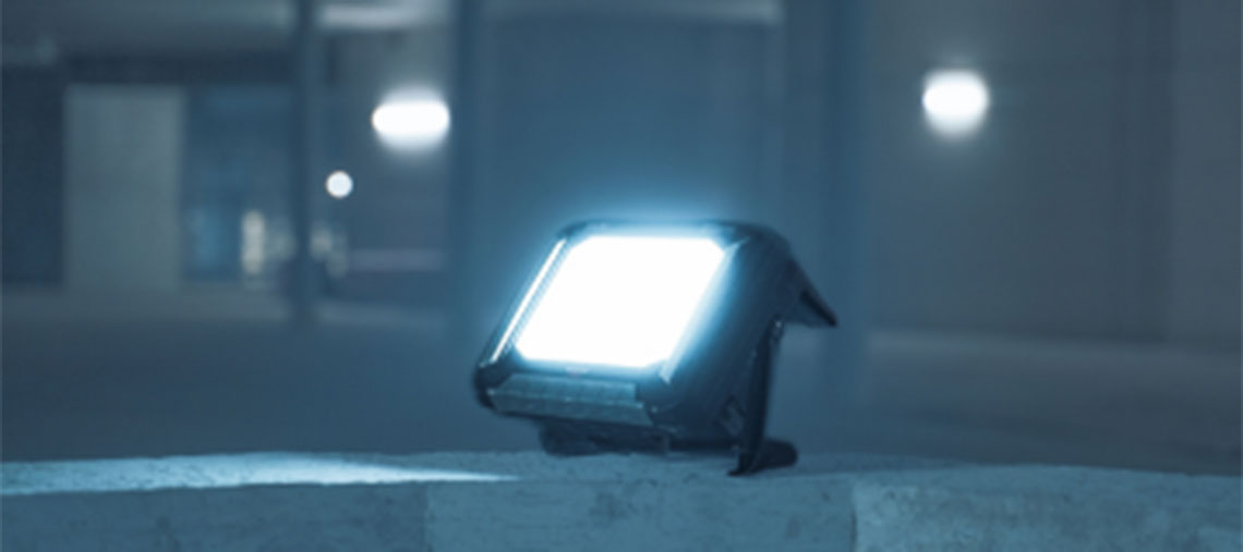 Ein Bosch Professional Baustrahler leuchtet auf einer grauen Oberfläche.