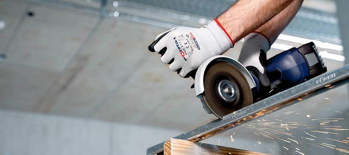 Ein Handwerker schneidet Metall mit einer blauen Bosch Professional Trennmaschine.