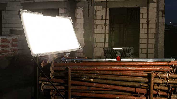 Ein helles Baustellenlicht steht auf einem Holzgerüst in einem Raum.