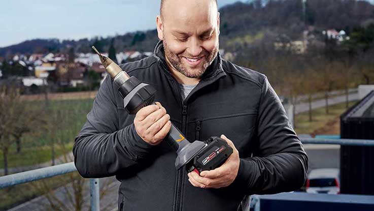 Ein Mann hält einen Bosch Professional Akku-Schrauber in der Hand.