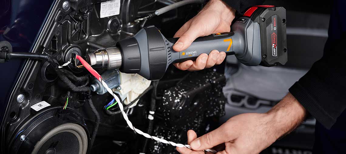 Ein Handwerker verwendet einen Steinel Heißluftfön an einem Kabel.