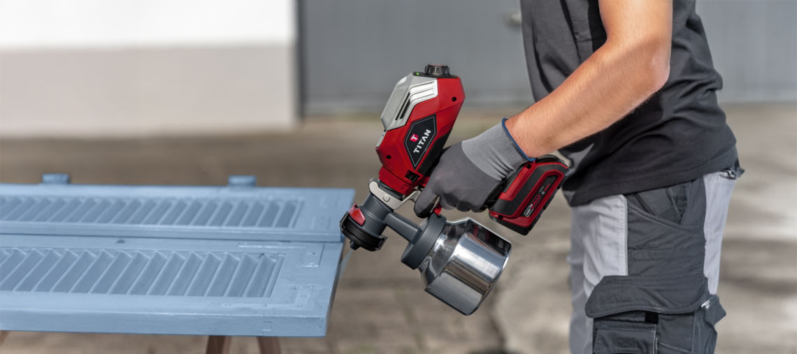 Ein roter Titan Farbsprühgerät wird von einer Person genutzt.