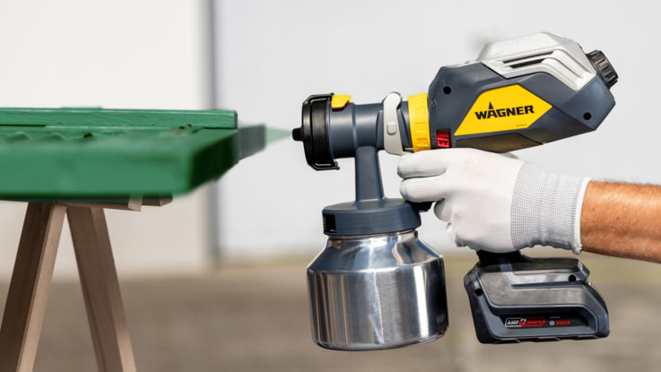 Ein Wagner Farbsprüher wird an einer grünen Oberfläche verwendet.